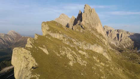 establishing aerial shot above seceda mountain cliffs in dolomites of italy