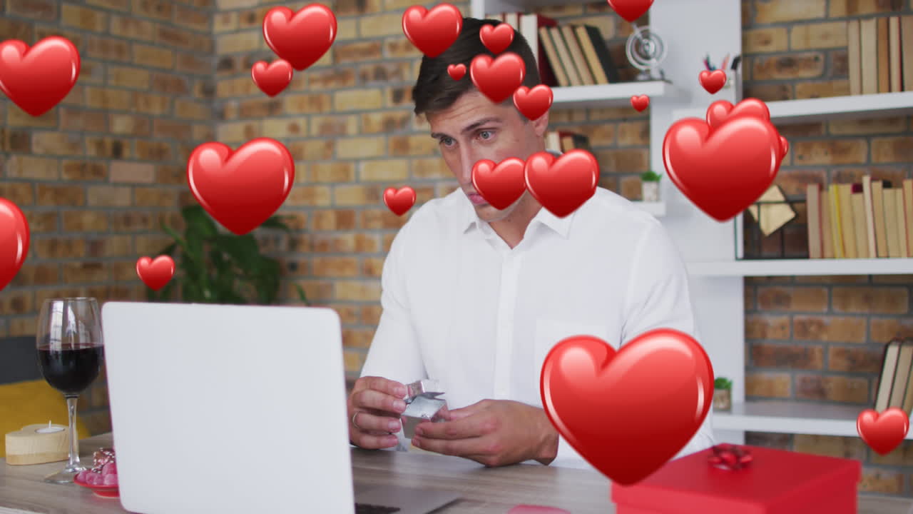 animación de corazones rojos sobre hombre caucásico proponiendo con anillo en una cita de video