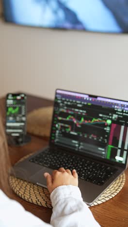 persona que cotiza en acciones en una computadora portátil