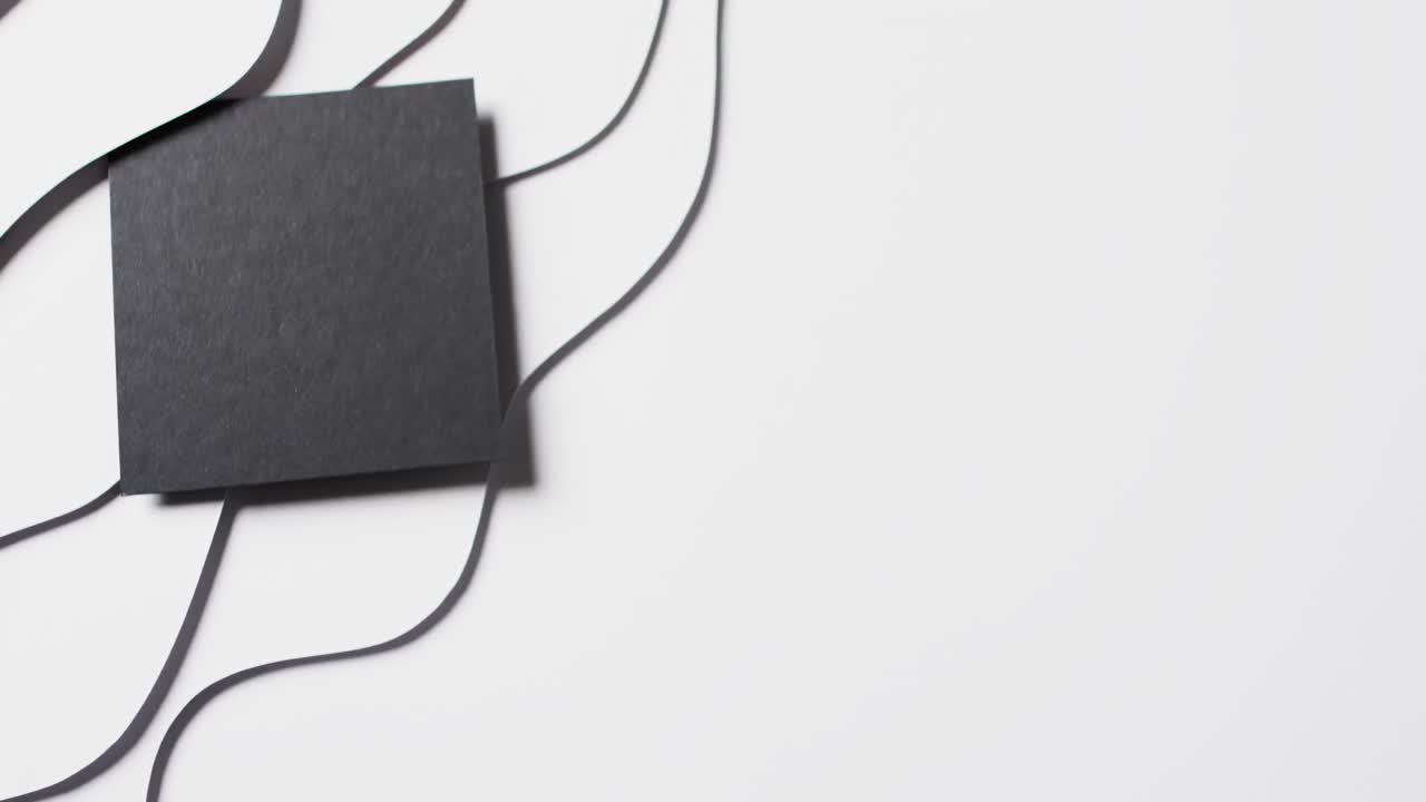 파도에 검은 종이의 사각형의 클로즈업의 비디오를 잘라  ⁇  배경에 공간을 복사