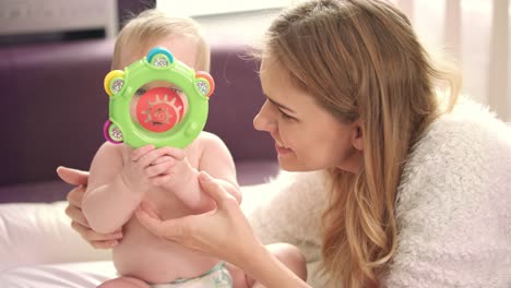 madre jugando con el bebé. niña de belleza jugando con el bebé sonajero
