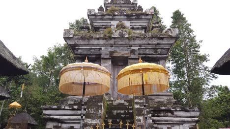 Hindu-Temple-Stone-Arch-Gate-Architecture-with-Umbrellas-at-Bali-Indonesia-Stone-Building-in-Pura-Mengening,-Tampaksiring,-Entrance-Door