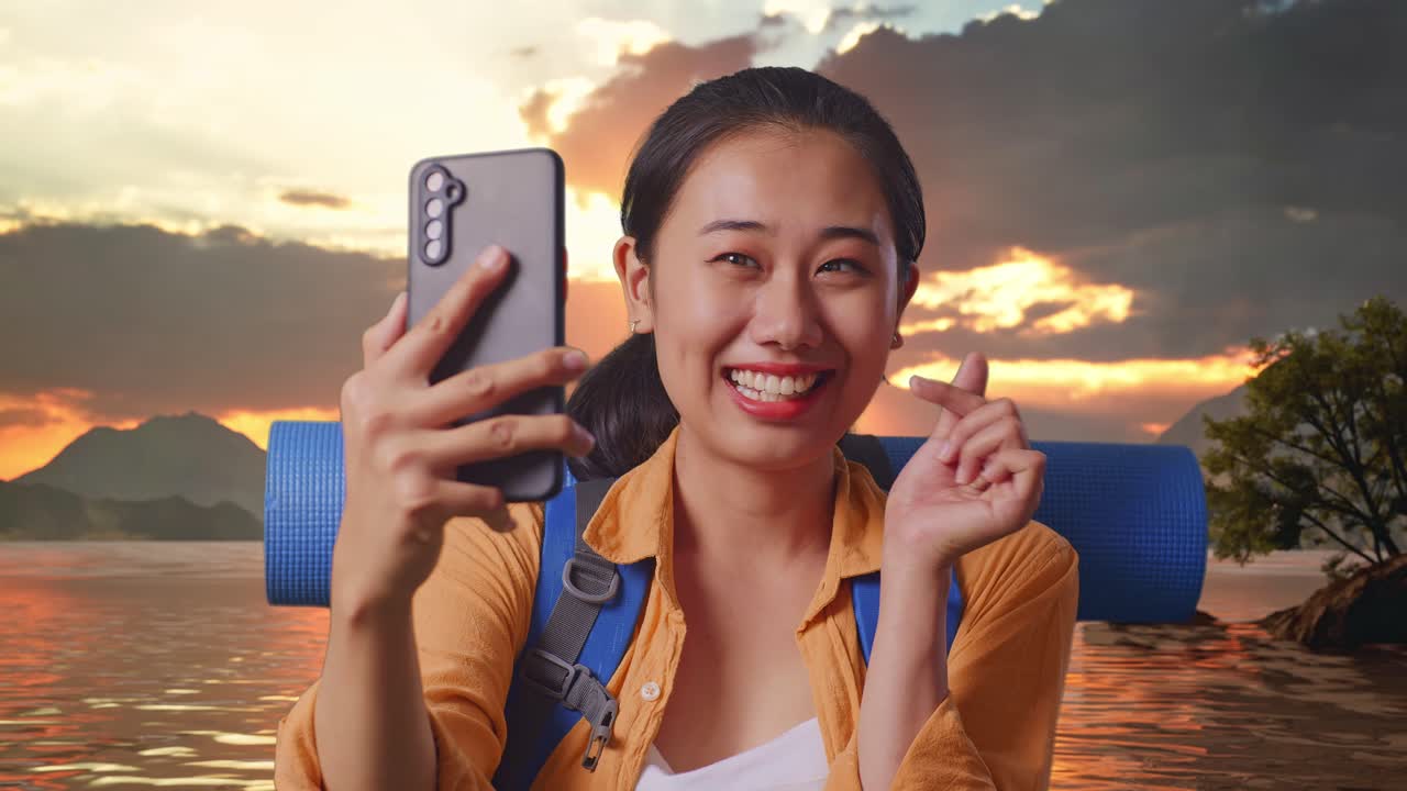 Close Up Of Asian Female Hiker With Mountaineering Backpack Taking A Selfie At A Lake During Sunset Time