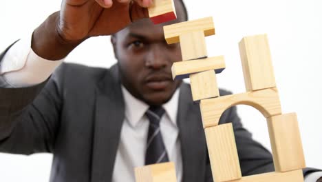 businessman playing with building blocks