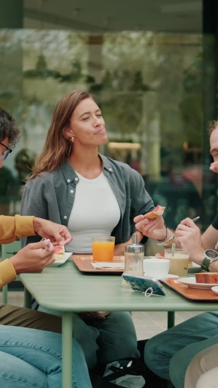 International joyful students drink at lunch, eating, talking and laughing