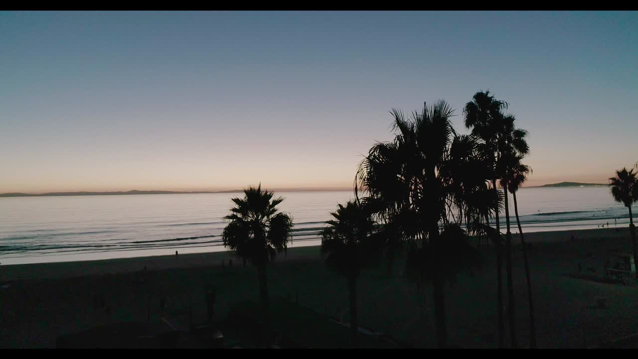 Filmato aereo di Newport Beach, California, con il molo, la spiaggia, l'acqua, surf, nuoto e bagnanti