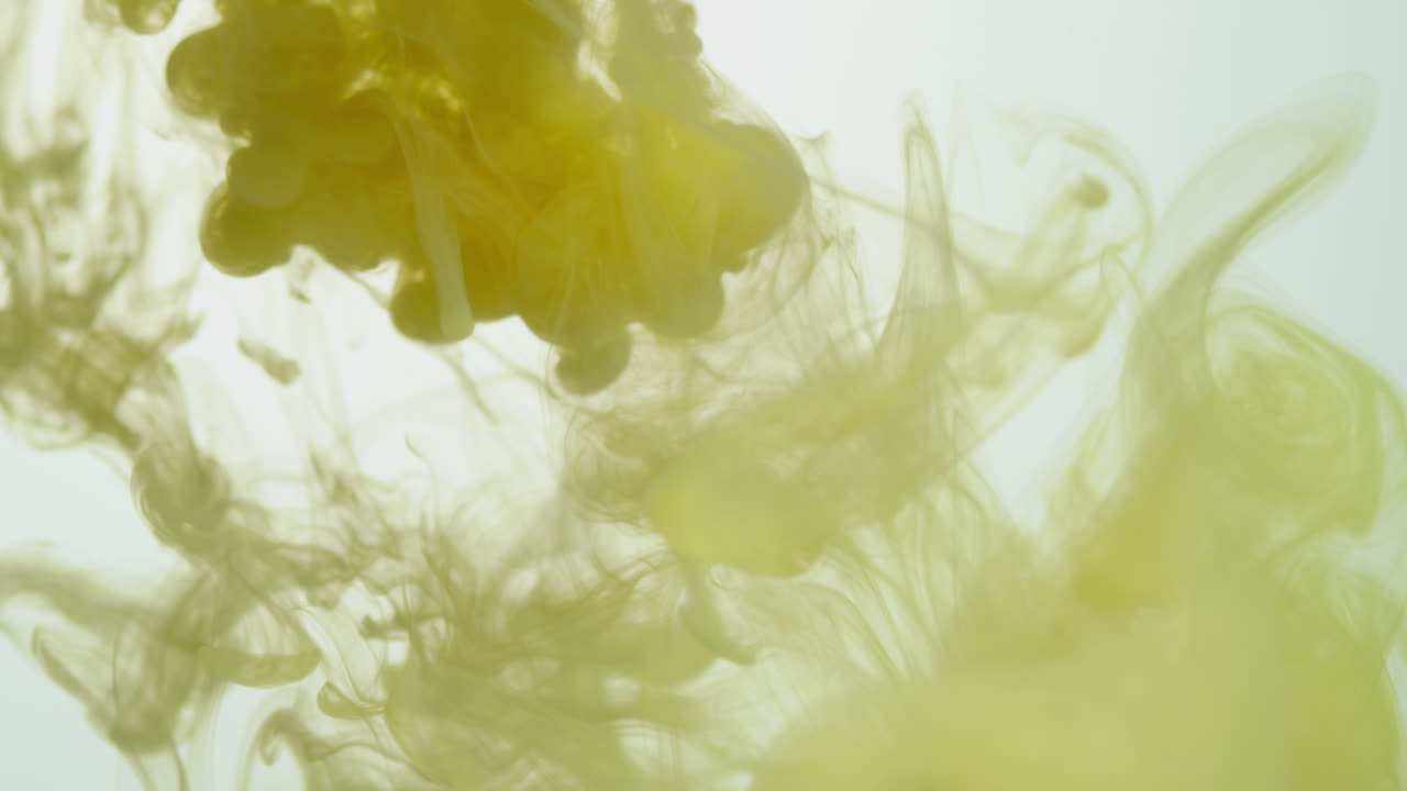 노란색 페인트 또는 염료가 색 배경에 물에 떨어지면 회전하는 다채로운 연기 배경을 만니다.