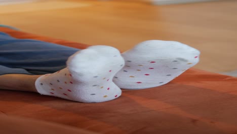 closeup of feet in white polka dot socks resting on a couch