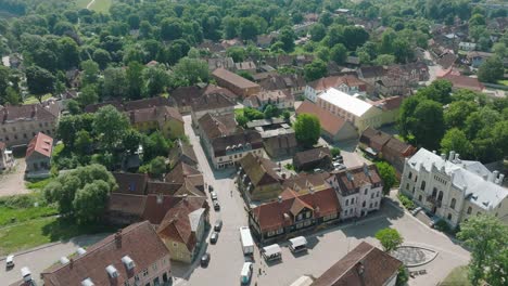 aerial establishing view of kuldiga old town , houses with red roof tiles, sunny summer day, travel destination, wide drone shot moving forward, tilt down