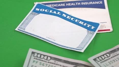 money placed around a social security and medicare cards tp illustrate retirement funds and health care insurance