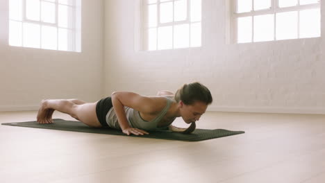 mujer de yoga saludable practicando pose de cobra disfrutando de un estilo de vida fitness haciendo ejercicio en un estudio de ejercicios de estiramiento en una colchoneta de ejercicios al amanecer.