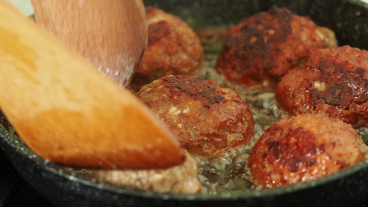 Patties of minced meat fried in stainless steel pan with oil