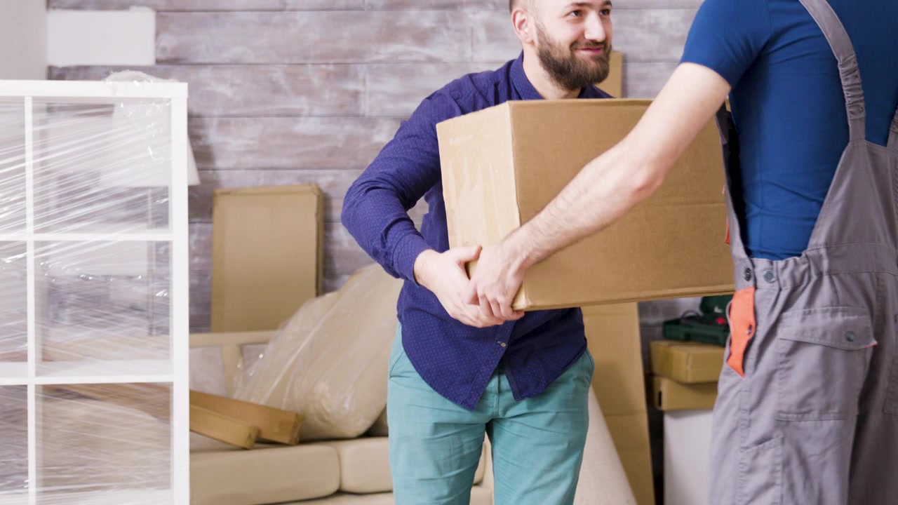 Couple Moving Into New Home and Unpacking Cardboard Boxes