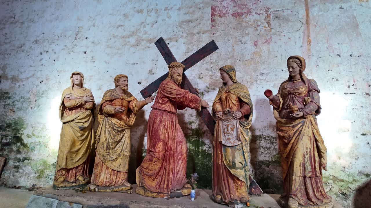 Antique wooden statues depicting Jesus Christ carrying the cross, meeting Saint Veronica, Stations of Cross scene for religious or historical content. Close-up
