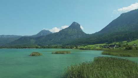 low-level drone voyage unveils austrian splendor: wolfgangsee lake's pristine waters, framed by the grandeur of bleckwand mountain