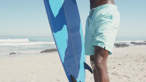 african american man holding a surfboard