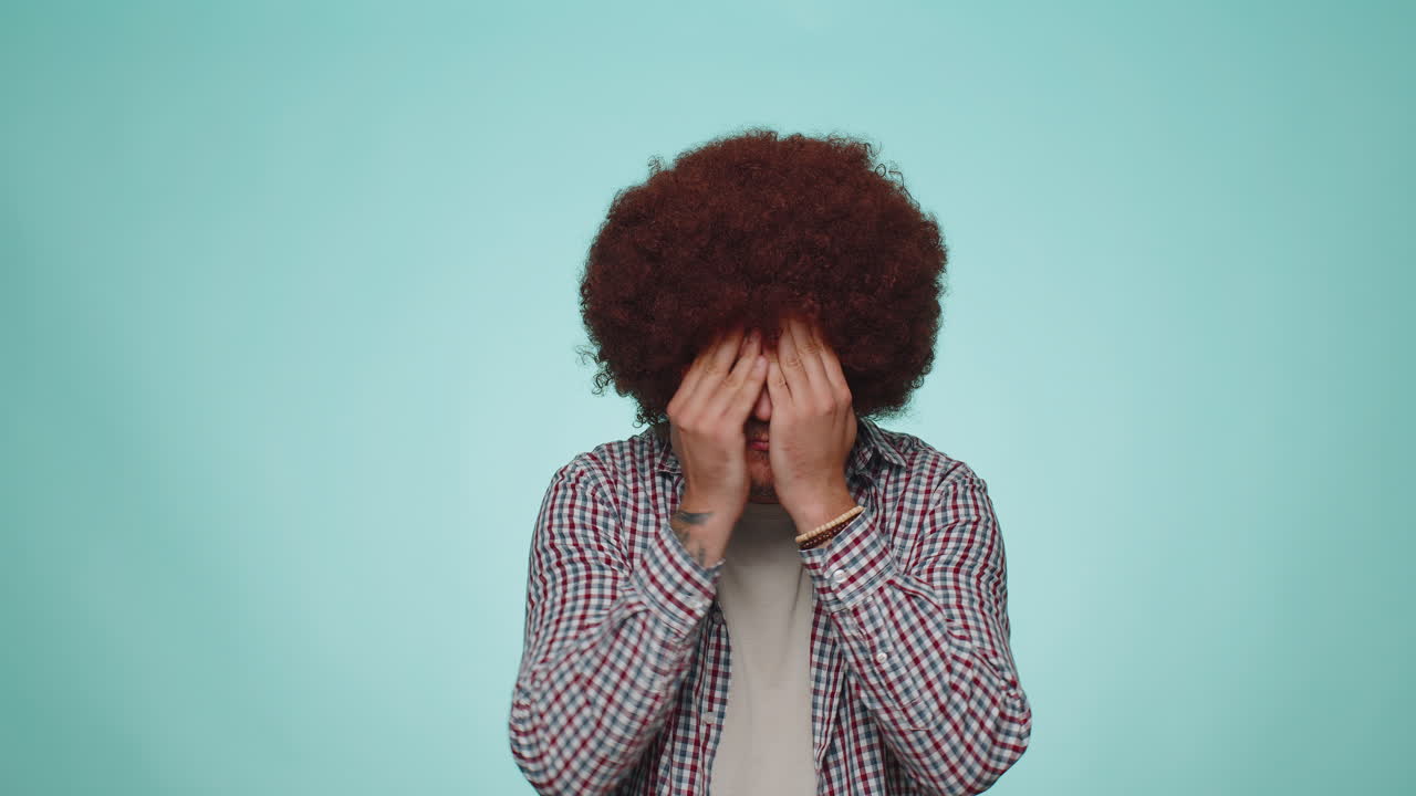 hombre curioso curioso cerrando los ojos con la mano y espiando a través de los dedos, escondiéndose y mirando, explorando