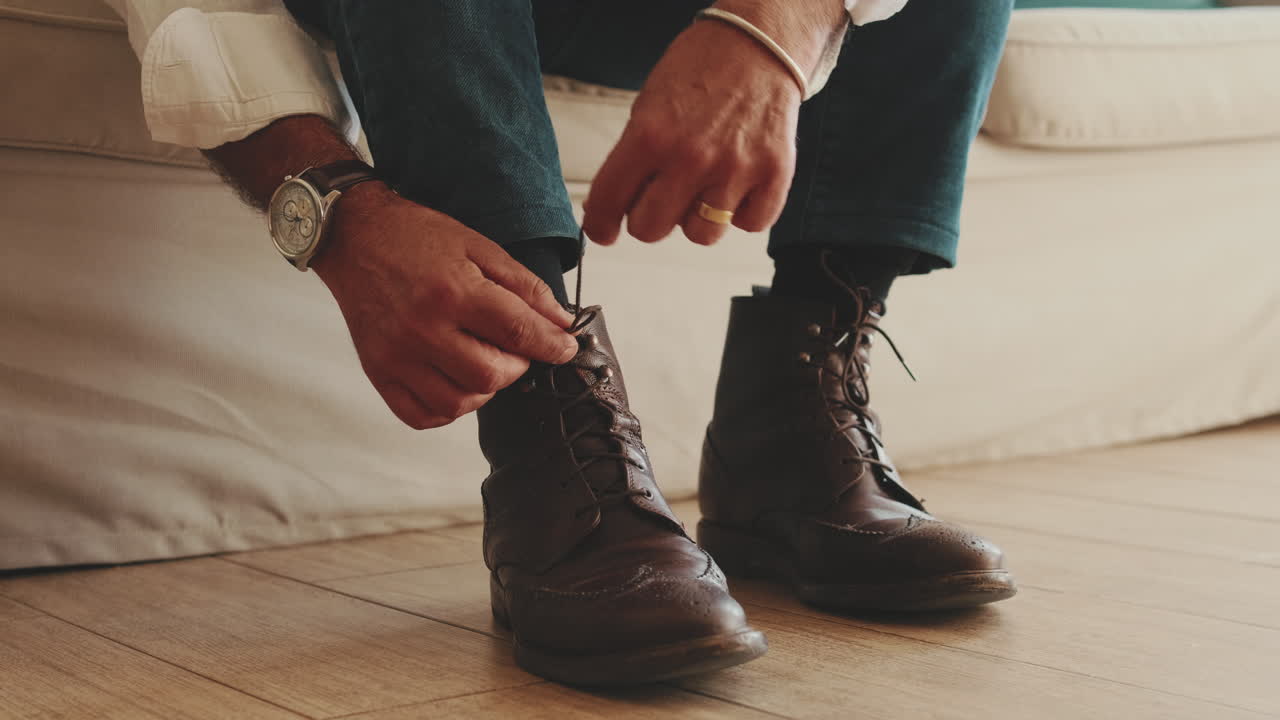 Uomo che si allaccia le scarpe su stivali in pelle marrone