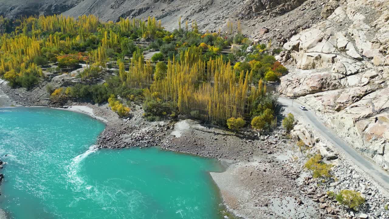 воздушный вид осенних деревьев в долине скарду рядом с бирюзовой рекой инд и горной дорогой