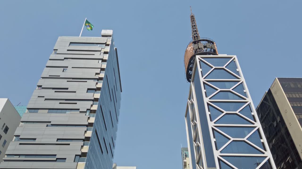 Low angle shot of modern building facades on Avenida Paulista, Brazilian flag