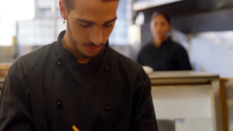Chef-checking-order-records-on-clipboard-4k
