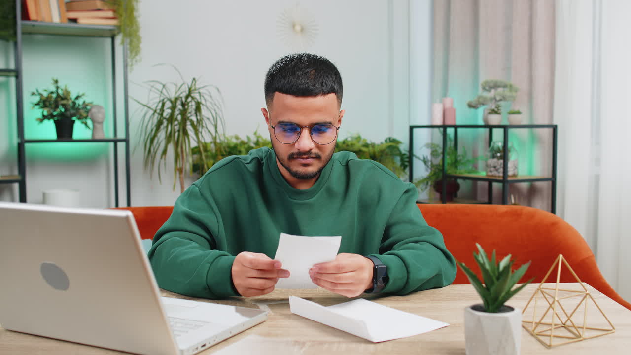 Man open envelope letter reads it feel happy career growth advance promotion bank loan approve