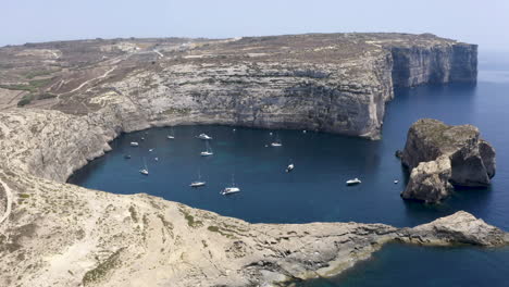 yates y barcos anclados bajo los acantilados rocosos de la bahía de dwerja, malta