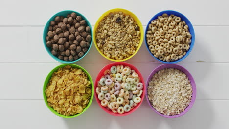 video of cereals in colorful bowls on wooden kitchen worktop