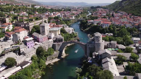 vista aérea más estática de la ciudad de mostar viejo puente y barcos en el río neretva en la base de la colina hum
