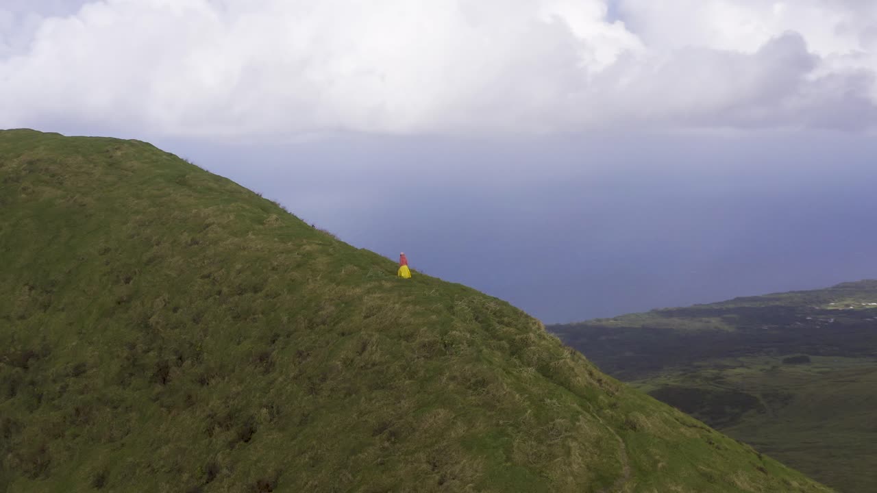 são jorge 섬, azores, 포르투갈에 있는 pico da esperança에 있는 vulcanic 무성한 녹색 산의 가장자리에 있는 길을 걷고 있는 아시아 말레이시아 중국 관광 여성 주위를 공전하는 드론