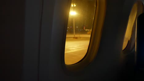 video from inside the plane through the windows of aircraft while taxiing on taxi way in the evening flight time