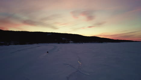 flying drone above a frozen lake in canada at golden hour