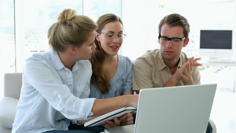 Colleagues-having-a-meeting-on-couch-with-laptop