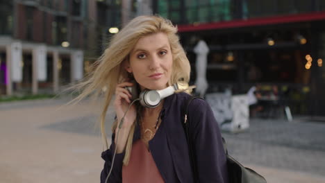 portrait of young beautiful blonde woman relaxing in city enjoying posing running hand through hair in city