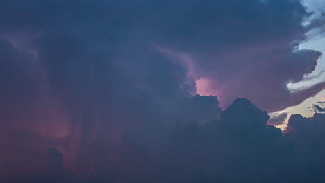 a lightning spark flashing on a moving cloud in the colourful sky at twilight