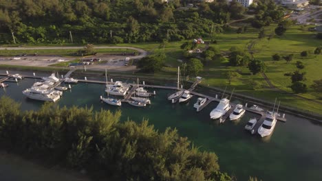 orbit drone shot of yachts parked at dock of american memorial park, saipan