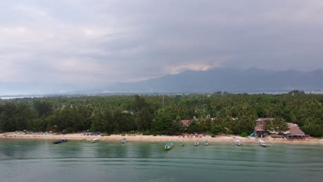 Green-island-with-mountains-in-the-background-from-aerial-view