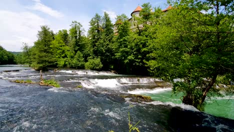 Stunning-view-of-a-river-and-waterfall-with-a-glimpse-of-a-castle-in-the-background