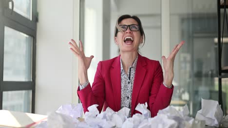 Stressed businesswoman with crumpled papers