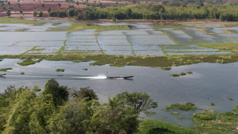 single traditional longtail boat on marshland channel, wide side angle aerial