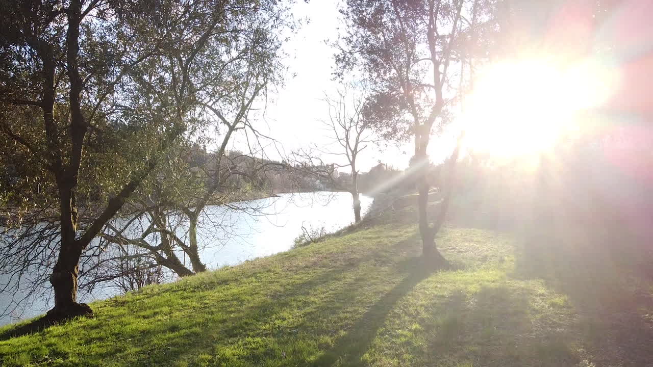Zooming out Riverside flying in Sunset drone above the Arno river. Girone small town near Fiesole Florence, in the Tuscany region of Italy. December 2019