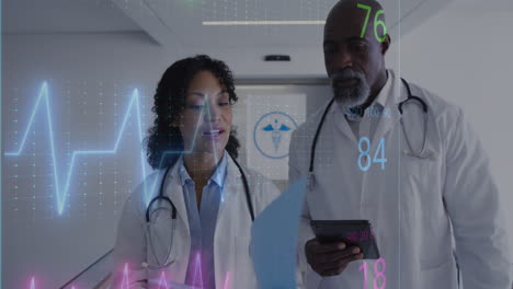 animation of heart rate monitor against diverse male and female doctors discussing at hospital