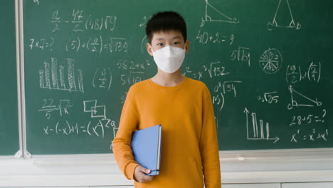 asian pupil with face mask looking at the camera.