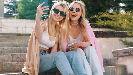 two friends taking selfies on stairs