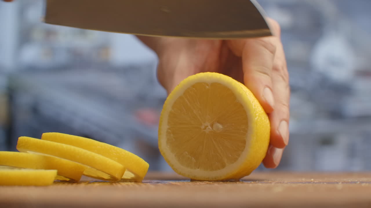 Cut with a knife on a wooden board close-up of a lemon in the kitchen. shred