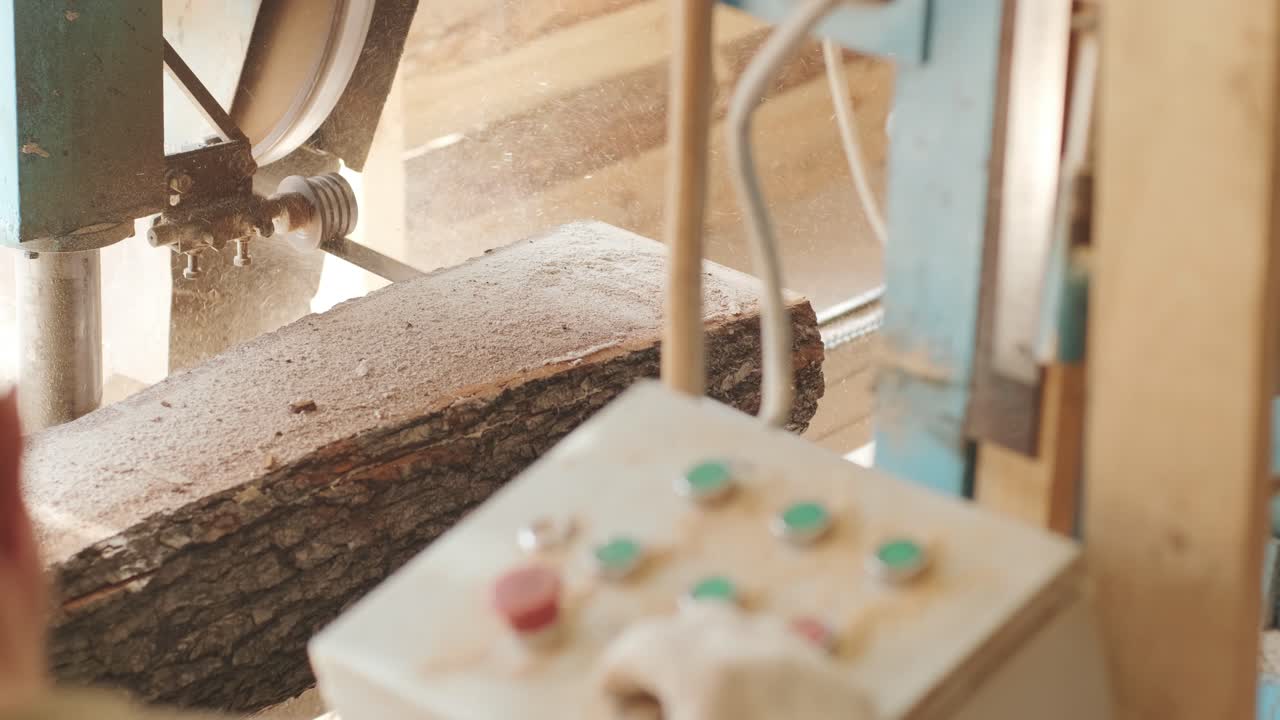 Sawing machine at wood production factory. Timber material processing and cutting at sawmill. Manufacturing process at lumber mill. Automatic Circular Sawing Machine