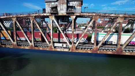 Eisenbahnwaggons,-Die-Auf-Einer-Alten-Brücke-über-Den-Fluss-Fahren