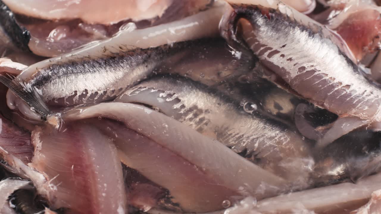 Fresh Sea sardines and Anchovy Fish and Mullus On Display On Ice On Market Store Shop. Seafood Fish Background, close up stand of small salty white fish.