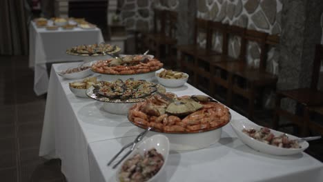 lavish buffet with an array of seafood dishes, including shrimp and mussels, set up on a long table in a rustic stone walled room, perfect for a festive gathering