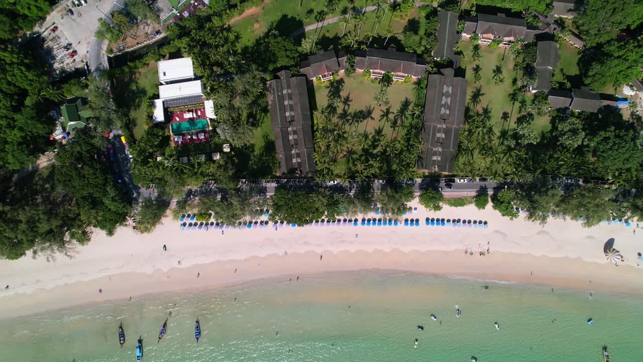 vista de arriba hacia abajo de un paraguas azul y un resort en una playa tropical de karon de arena blanca con aguas azul turquesa y barcos anclados en phuket, tailandia